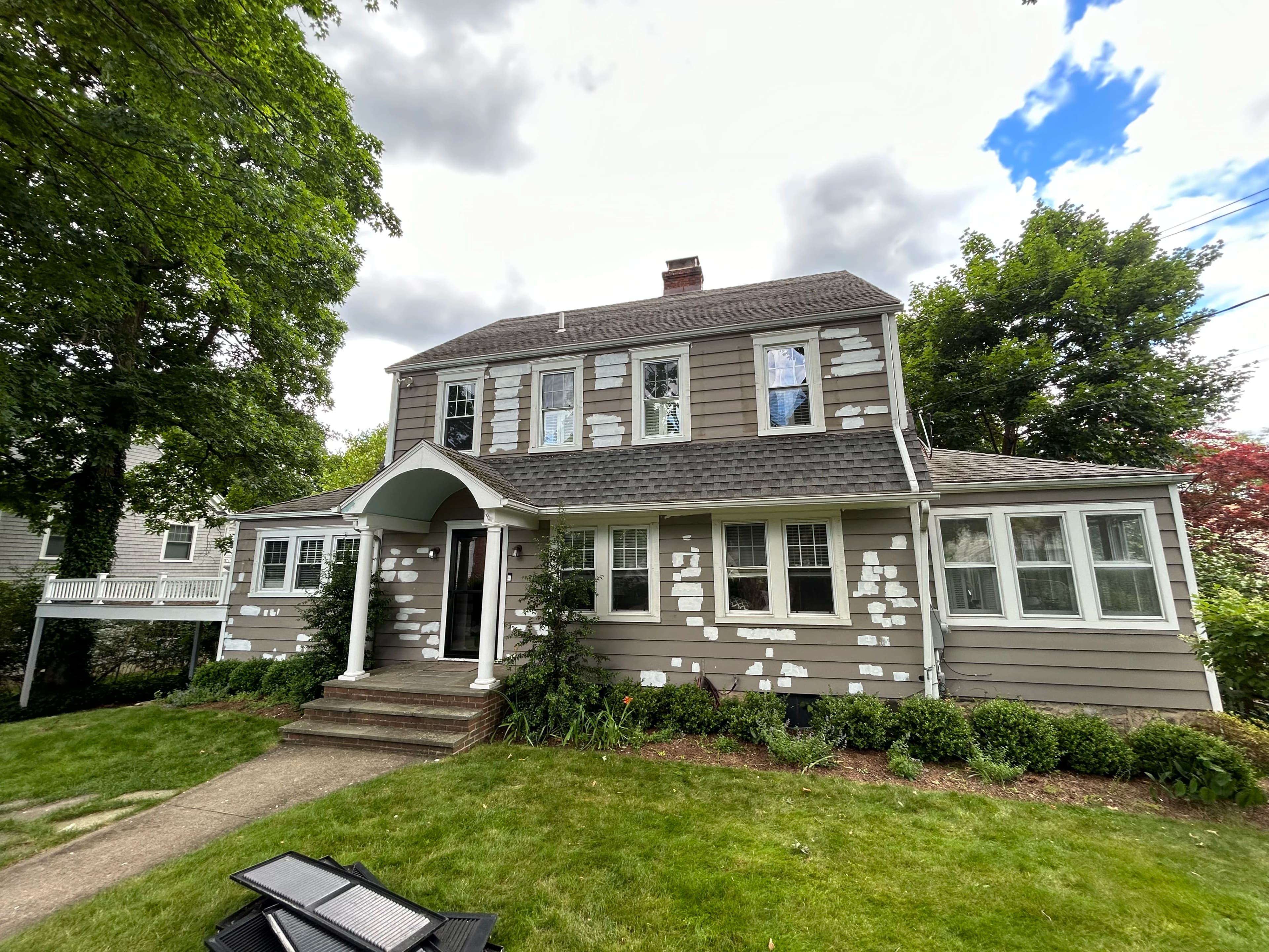 Front shot of a house with painted white lines indicating where a paint correction is needed